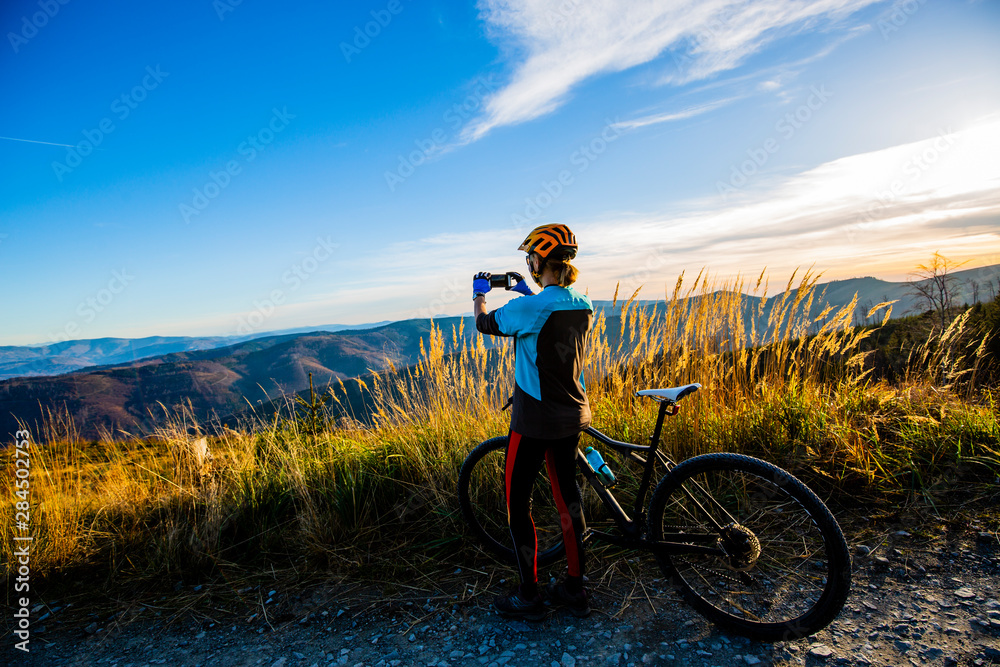 Mountain biking woman riding on bike in summer mountains forest landscape. Woman cycling MTB flow trail track. Outdoor sport activity. Mountain biking woman riding on bike in summer mountains forest landscape. Woman cycling MTB flow trail track. Outdoor sport activity.