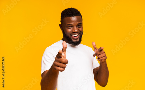 Flirty black man pointing at camera with both hands