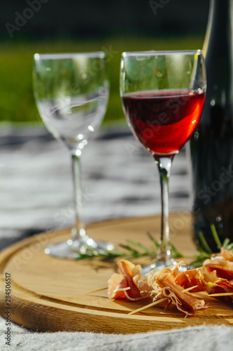 picnic in nature a light meal under wine, on a wooden background two glasses of red wine