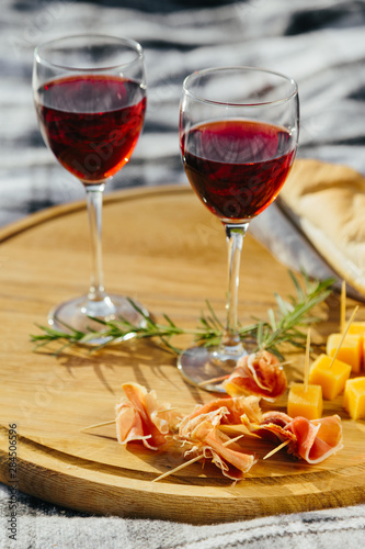 picnic in nature a light meal under wine, on a wooden background two glasses of red wine