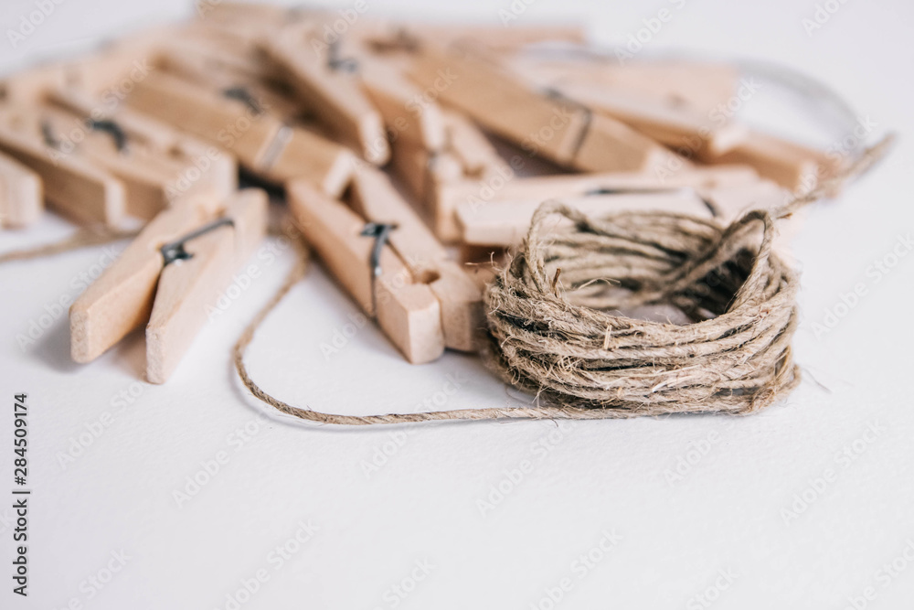Wooden clothespins with rope on white background. View from above. Copy space