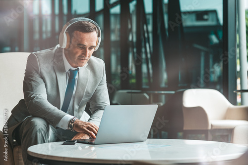 Search for information. Businessman is using laptop in the office. Copy space on the right side