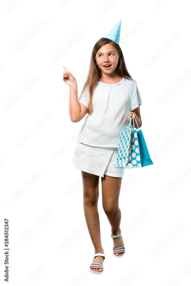 A full-length shot of a Little girl at a birthday party holding a gift bag standing and thinking an idea on isolated white background A full-length shot of a Little girl at a birthday party holding a gift bag standing and thinking an idea on isolated white background
