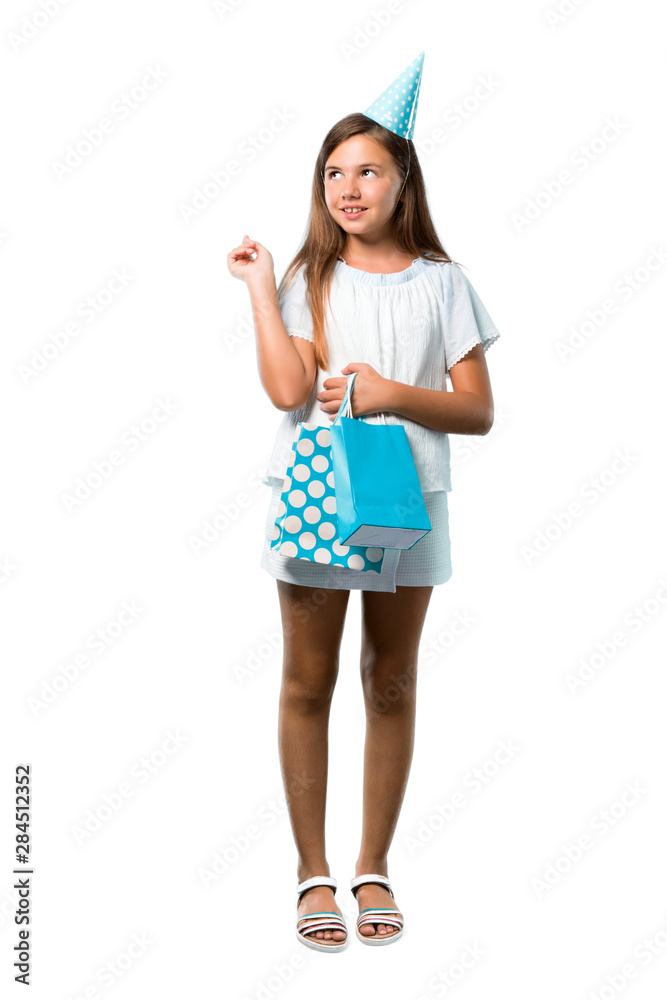 A full-length shot of a Little girl at a birthday party holding a gift bag pointing with the index finger a great idea on isolated white background
