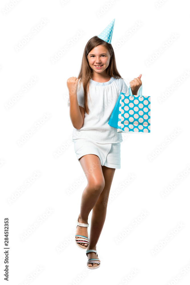 A full-length shot of a Little girl at a birthday party holding a gift bag celebrating a victory on isolated white background A full-length shot of a Little girl at a birthday party holding a gift bag celebrating a victory on isolated white background