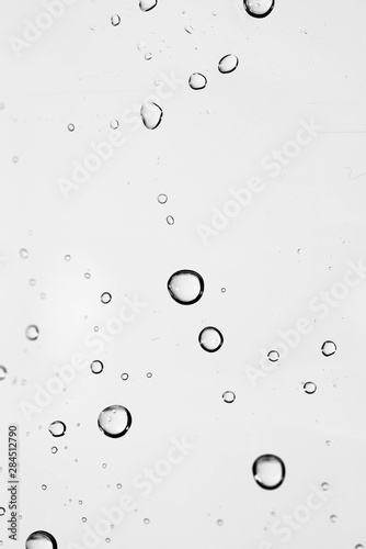 Abstract waterdrops on plastic bottle close up vertical macro shot for background in black and white.