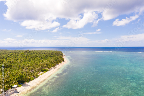 Seascape, coast of the island of Siargao, Philippines. Blue sea with waves and sky with big clouds, top view.