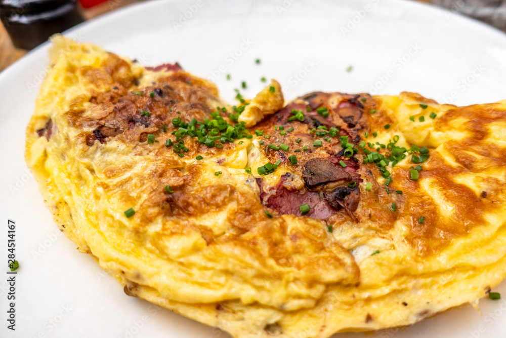 Breakfast food - Omelette with meat, cheese, onion on the white plate Breakfast food - Omelette with meat, cheese, onion on the white plate