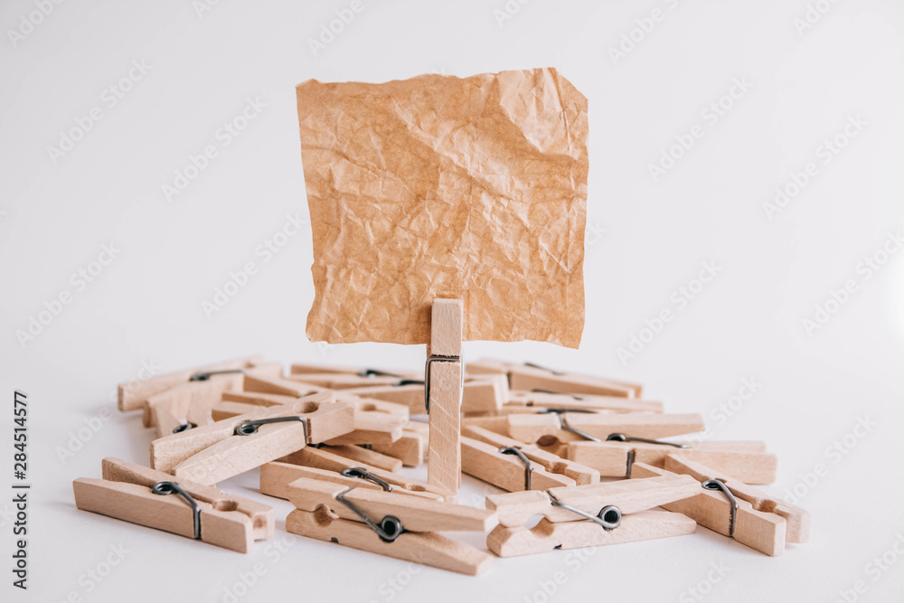 Woodenl clothespins, paper clip and brown sticker on white background. Isolated on white. Place for your text Woodenl clothespins, paper clip and brown sticker on white background. Isolated on white. Place for your text
