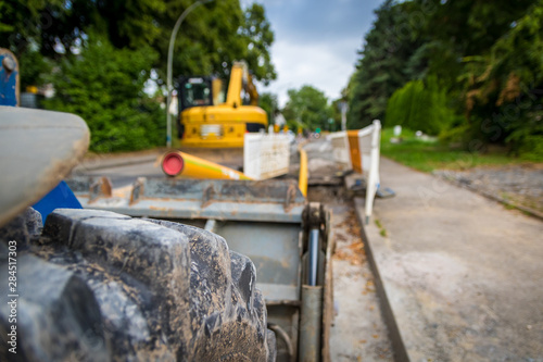 Radladerreifen und Schaufel, Bagger auf Straßenbaustelle