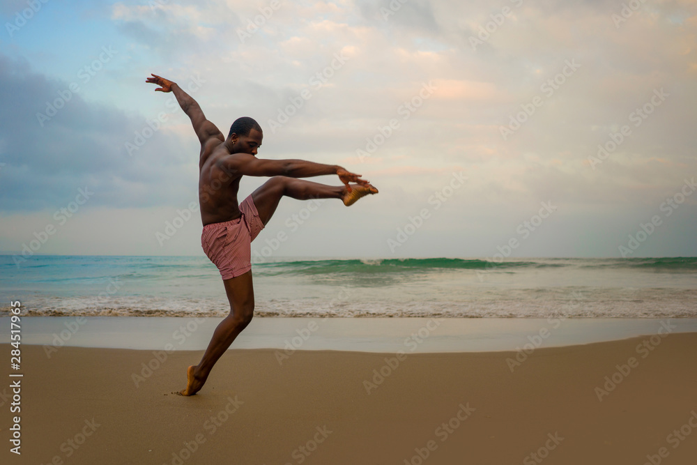 dramatic contemporary dance choreographer doing ballet beach workout, young attractive and athletic afro black American man dancing on sunrise dramatic contemporary dance choreographer doing ballet beach workout, young attractive and athletic afro black American man dancing on sunrise