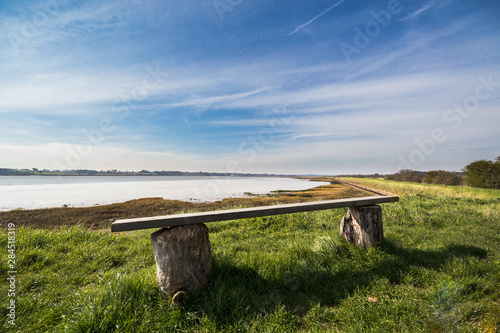 An empty bench in rural Suffolk countryside over looking the River Deben in Suffolk photo