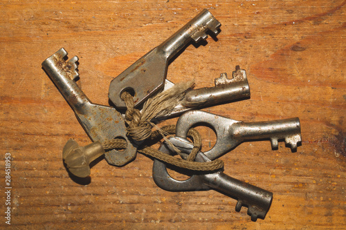 Bunch of old keys isolated on wooden background
