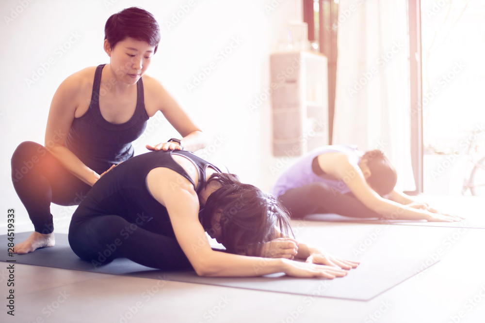 Fototapeta premium Young woman practicing yoga in gray background.Young people do yoga indoor