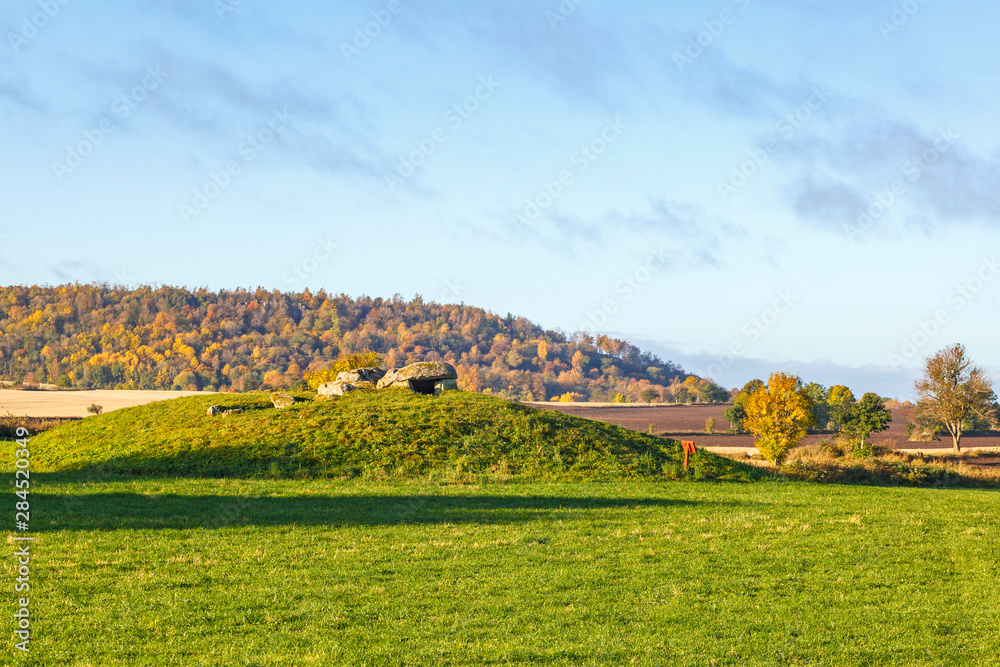 Passage grave on a hill in a rural landscape with autumn colors