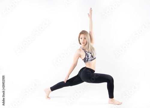 Sporty Asian young woman doing yoga practice isolated on white background. © anon