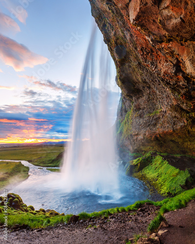 Format zdjęć w formacie Instagram 5x7 w naturalnym przetwarzaniu - wodospad Seljalandsfoss na Islandii, malownicza scena zachodu słońca. Letnie białe noce na Islandii.