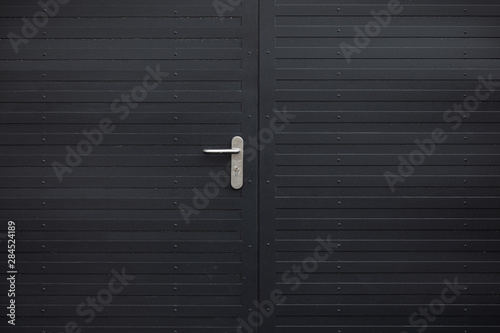 Close-up of black metal door with handle photo