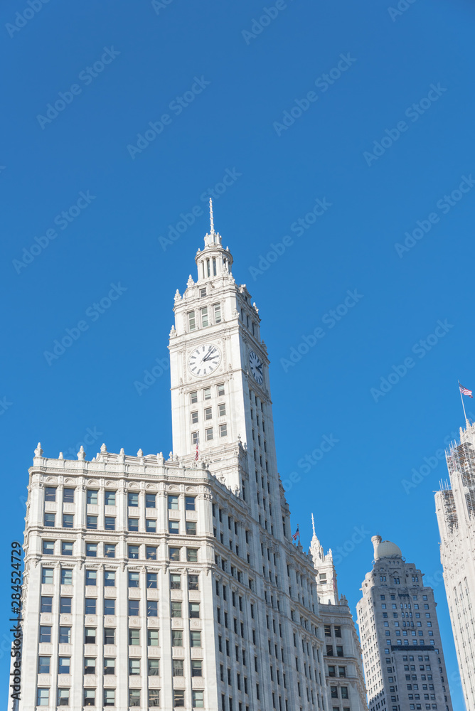 Lookup view of typical skyline building with rooftop tower clock in Chicago downtown Lookup view of typical skyline building with rooftop tower clock in Chicago downtown