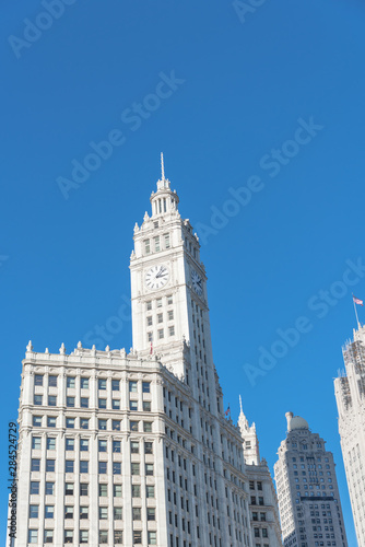 Lookup view of typical skyline building with rooftop tower clock in Chicago downtown