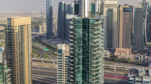 Aerial top view of Dubai Marina evening timelapse. Modern towers and traffic on the road