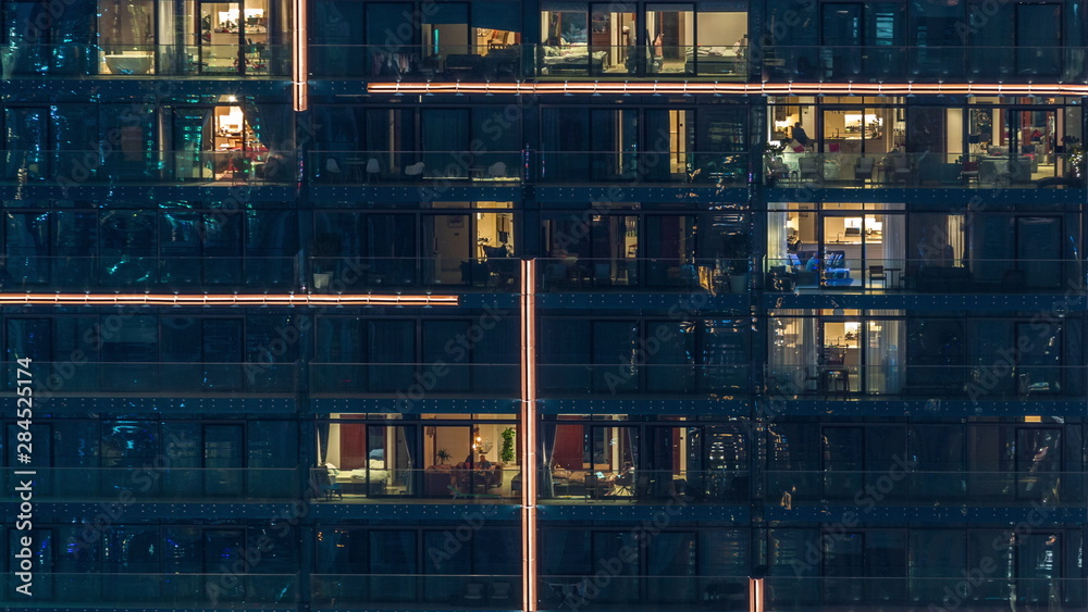 Lights in windows of modern multiple story building in urban setting at night timelapse - obrazy, fototapety, plakaty 