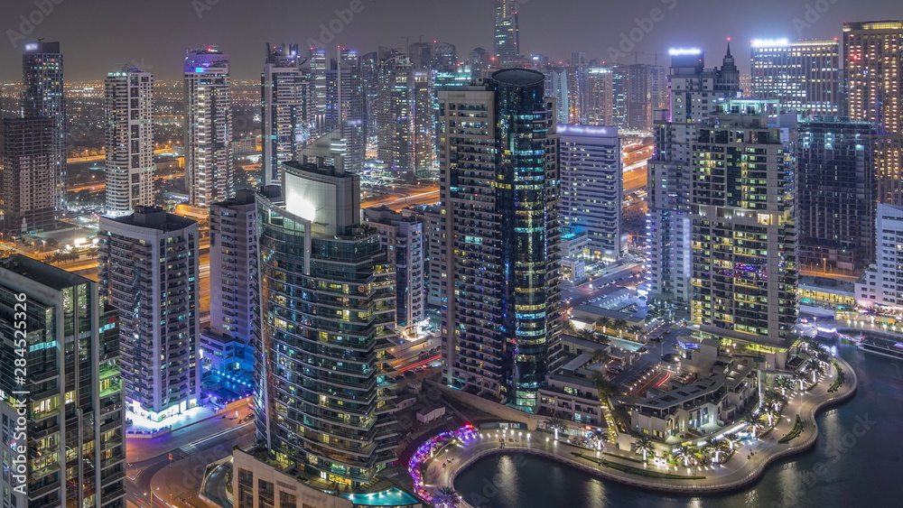 Obraz premium Aerial top view of Dubai Marina night timelapse. Modern towers and traffic on the road