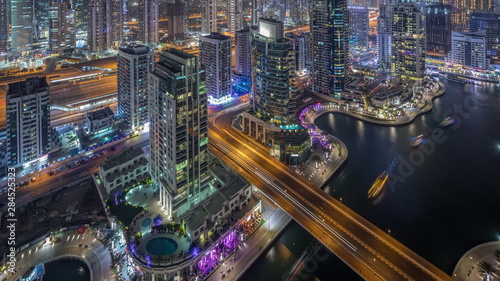 Aerial top view of Dubai Marina night timelapse. Modern towers and traffic on the road