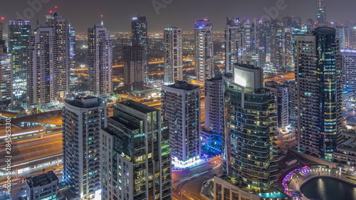 Aerial top view of Dubai Marina night timelapse. Modern towers and traffic on the road