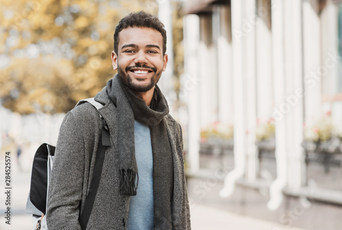 Handsome joyful man autumn portrait. Smiling men student wearing warm clothes in a city in winter