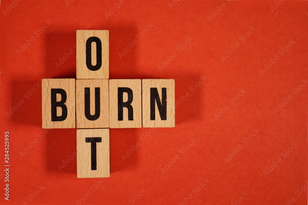 Obraz premium Burnout Word Written In Wooden Cube. Burn out, cube with letters. dice with text. concept of the destruction of shortcomings, fears, burnout at work, daily routine. medical or health care concept 