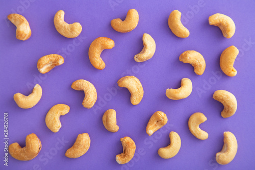 Cashews pattern on a purple background. Nuts creative layout. Top view