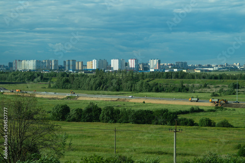 Urban cityscape panoramic view. horizon line with buildings. landscape with town and forest. city into a distance © maxkolmeto