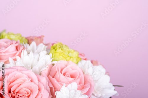 Bouquet of pink roses and white chrysanthemums  pink background  copy space