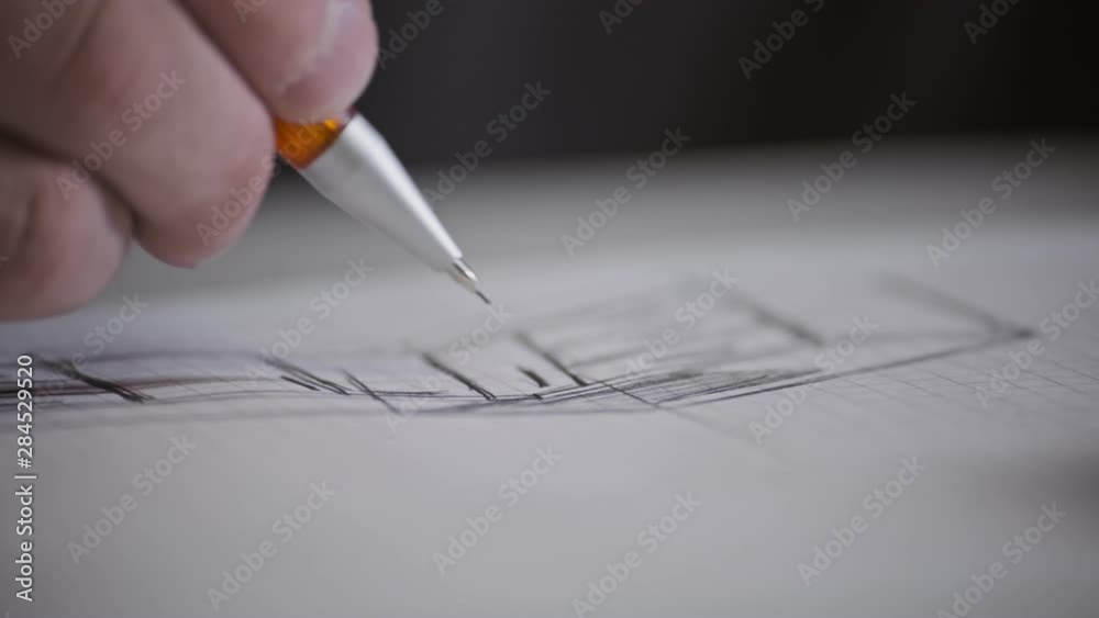 Male architect at work. Architect Hands. Pencil in hand of architect. Engineer works with drawings. Artist drawing with pencil. Close-up view