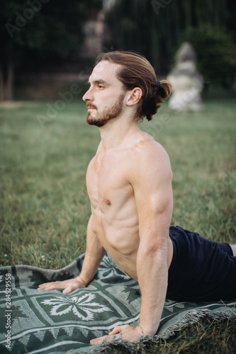 sporty man practicing yoga outdoor photo