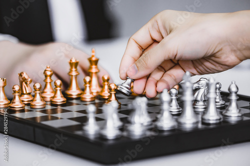 Hand of businessman play chess game