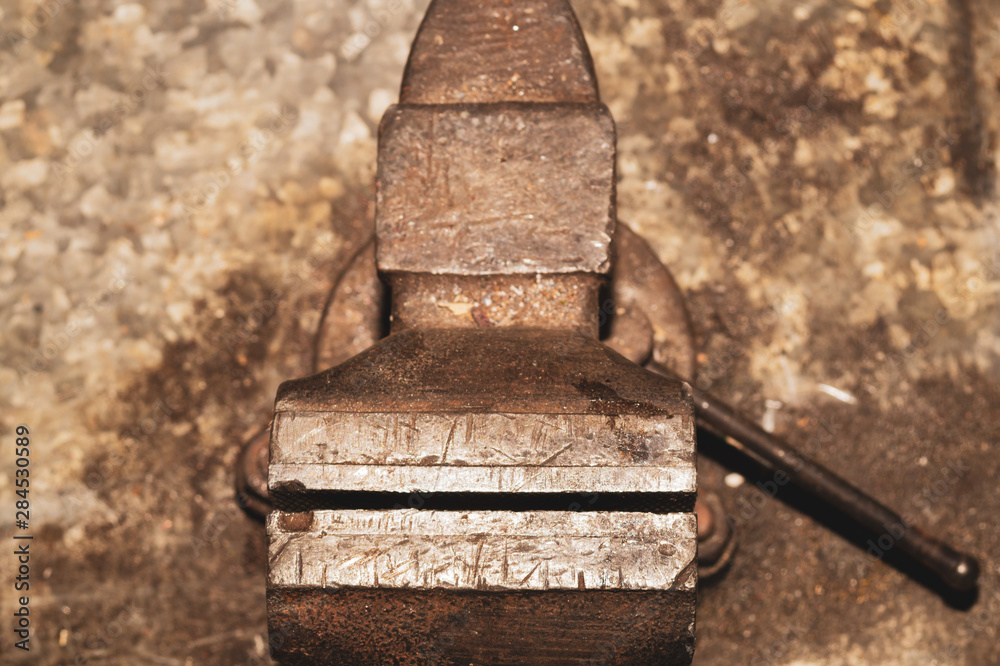 Old bench vise on a metal workbench. working tool Old bench vise on a metal workbench. working tool