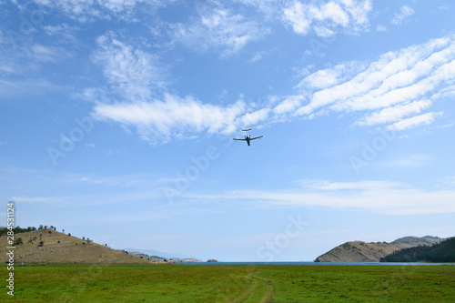 Amphibian aircraft flies for refueling by water to extinguish forest fires in Irkutsk Region. Lake Baikal  Small Sea Strait