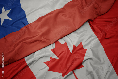 waving colorful flag of canada and national flag of chile.