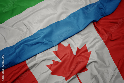 waving colorful flag of canada and national flag of sierra leone.