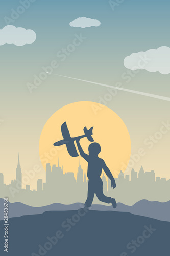 The boy runs up a hill with a toy plane. Silhouette of a child on a background of a city skyline, a sun, a sky and a plane flying in a distance. The concept of happiness and freedom of children.