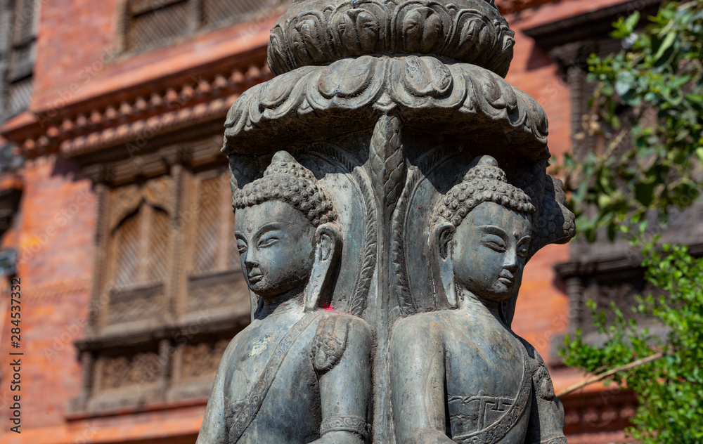 .close up of a Buddhist statue with a blurred wooden balcony in the background