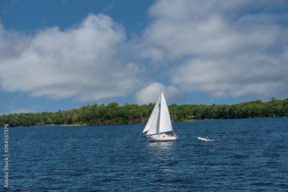 Fototapeta premium Lone sailboat sailing home to the bay