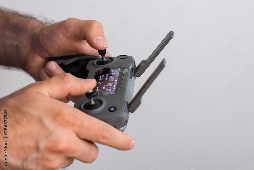 Hands with remote controller of drone outside. Man using RC for flying by drone. Hands with remote controller of drone outside. Man using RC for flying by drone.