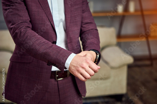 Businessman wears a jacket,male hands closeup,groom getting ready in the morning before wedding ceremony