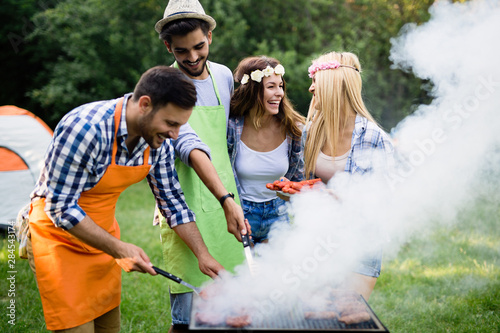 Group of friends making barbecue in the nature