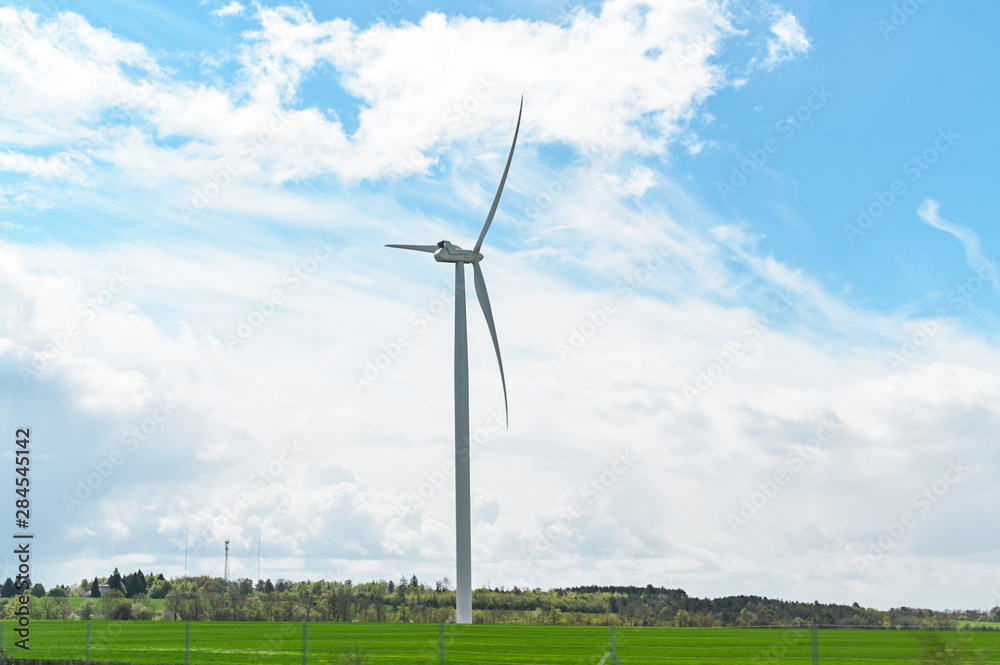 Windmills on a green field and blue sky. Green technologies in the modern world. Free space for text. Windmills on a green field and blue sky. Green technologies in the modern world. Free space for text.