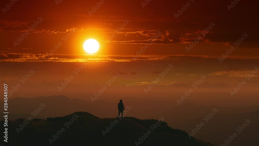 The male standing on a mountain top on a sunrise background. time lapse The male standing on a mountain top on a sunrise background. time lapse