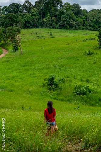 Young asia woman in a green field,enjoying in the sunny summer day. © max_play